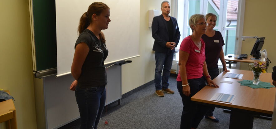 Erste Informationsflut für den Kurs 18A (GKKP): Nadine Weis (li), am Tisch die Kursleitungen Frau Rieder (li) und Frau Heinz sowie Herr Beer (stellv. Schulleitung) im Hintergrund